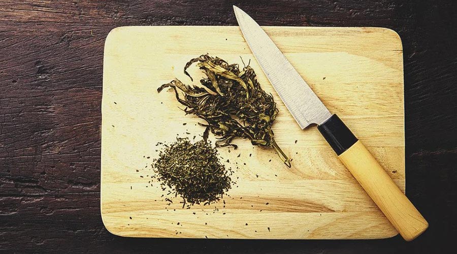 grind weed with knife chopping board